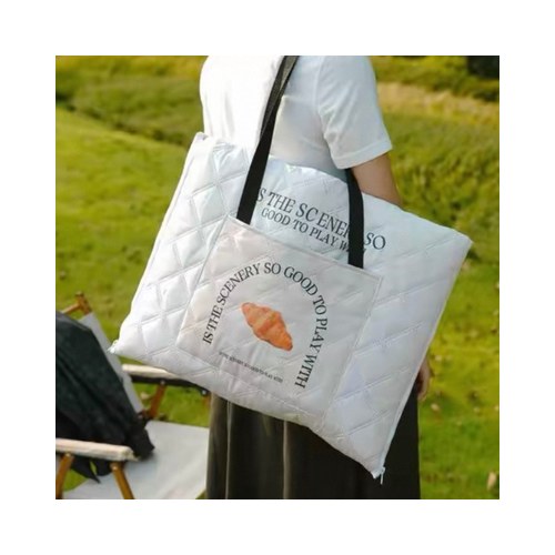 Custom foldable picnic mat tote bag folded and carried on the shoulder with a printed logo panel
