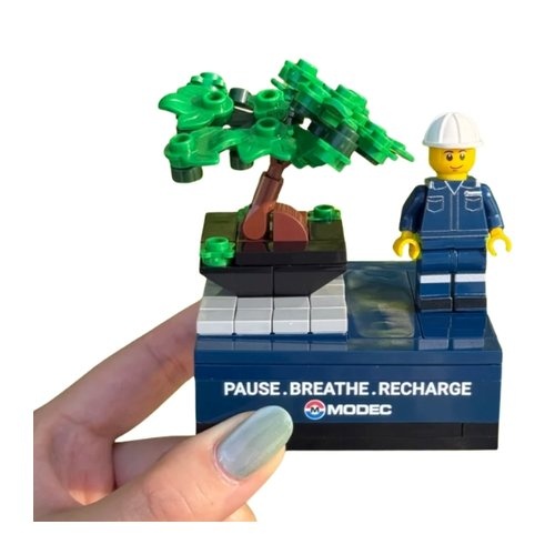 Custom brick bonsai desk display with minifigure in coveralls and printed slogan base