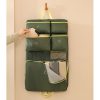 Custom travel organiser hanging from a hook with labelled compartments being filled, Malaysia