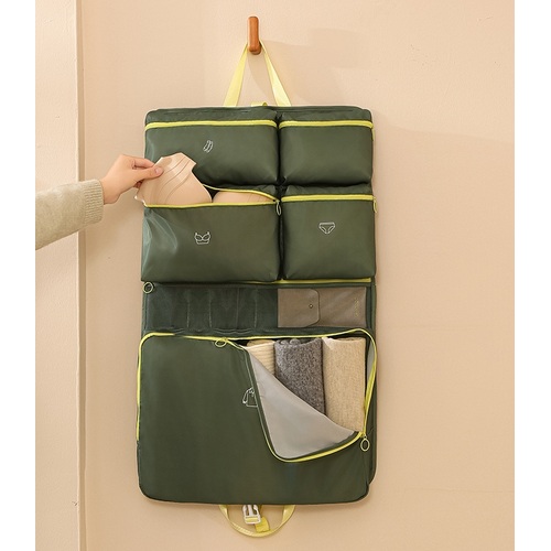 Custom travel organiser hanging from a hook with labelled compartments being filled, Malaysia