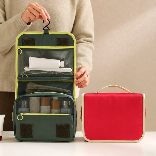 Custom travel toiletry bag held open by its swivel hook showing the clear and mesh pockets, Malaysia